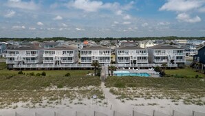 A beachfront hotel with multiple-story buildings, a swimming pool, and a sandy beach area. - "Waters Edge 435-A" - Oceanfront Condo w/ Community Pool, 2 Bedrooms / 2 Bathrooms (Holden Beach)