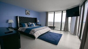 Une chambre d’hôtel moderne dotée d’un grand lit, d’une télévision à écran plat et d’un balcon avec vue.