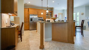 A spacious kitchen with wooden cabinets, stainless steel appliances, and a central island. - Castle by the Sea 7BR/8BA Luxury Home with Elevator (Hilton Head Island)