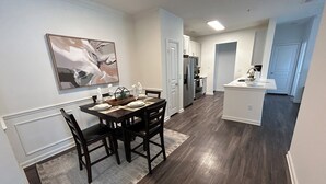 A modern kitchen with dark wood flooring, white cabinetry, and a central island. - Fabulous 3 Bedroom/ 2 Bath in Alpharetta (Alpharetta)
