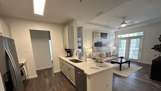 A modern kitchen with a central island, built-in appliances, and a dining area with a sofa and coffee table. - Fabulous 3 Bedroom/ 2 Bath in Alpharetta (Alpharetta)