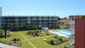 A modern building with a swimming pool and landscaped garden.