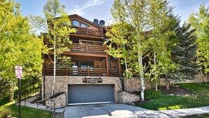 Eine zweistöckige Lodge mit Steinverkleidung und einem Holzbalkon.
