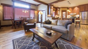 A spacious living room with a sofa, coffee table, and dining area.