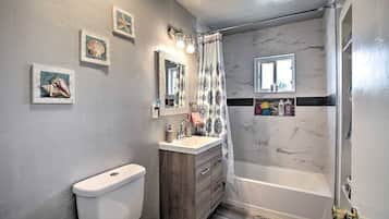 Un baño con inodoro, tocador y bañera.