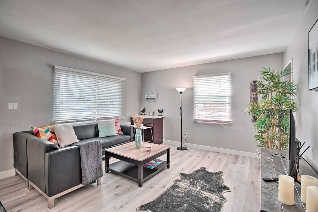 Un salon moderne avec un canapé gris, une table basse et un tapis noir.