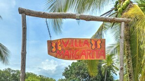 Un camino conduce a un edificio con un cartel que dice "Villa Margarita".