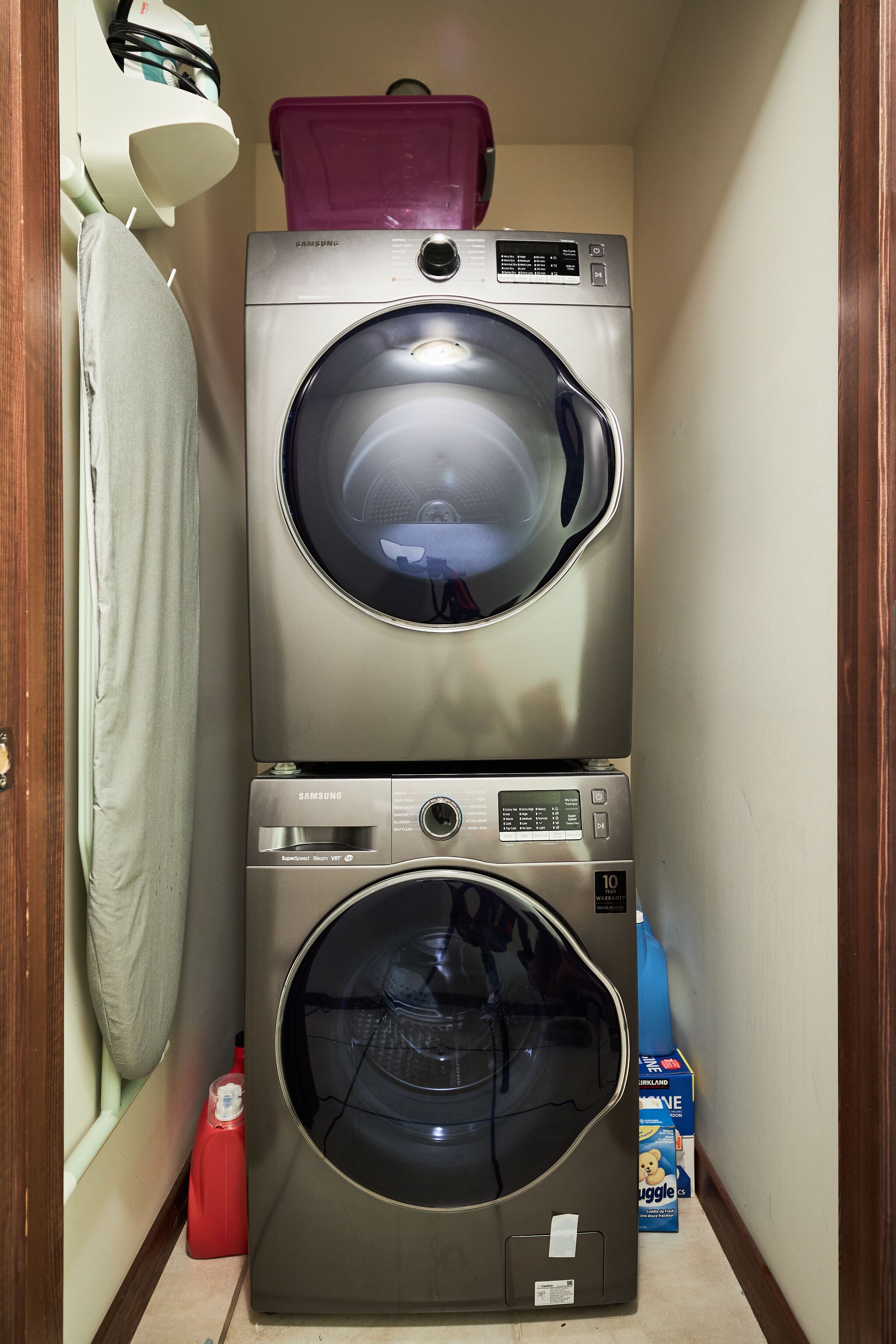 A compact laundry room with two stacked front-loading washing machines.