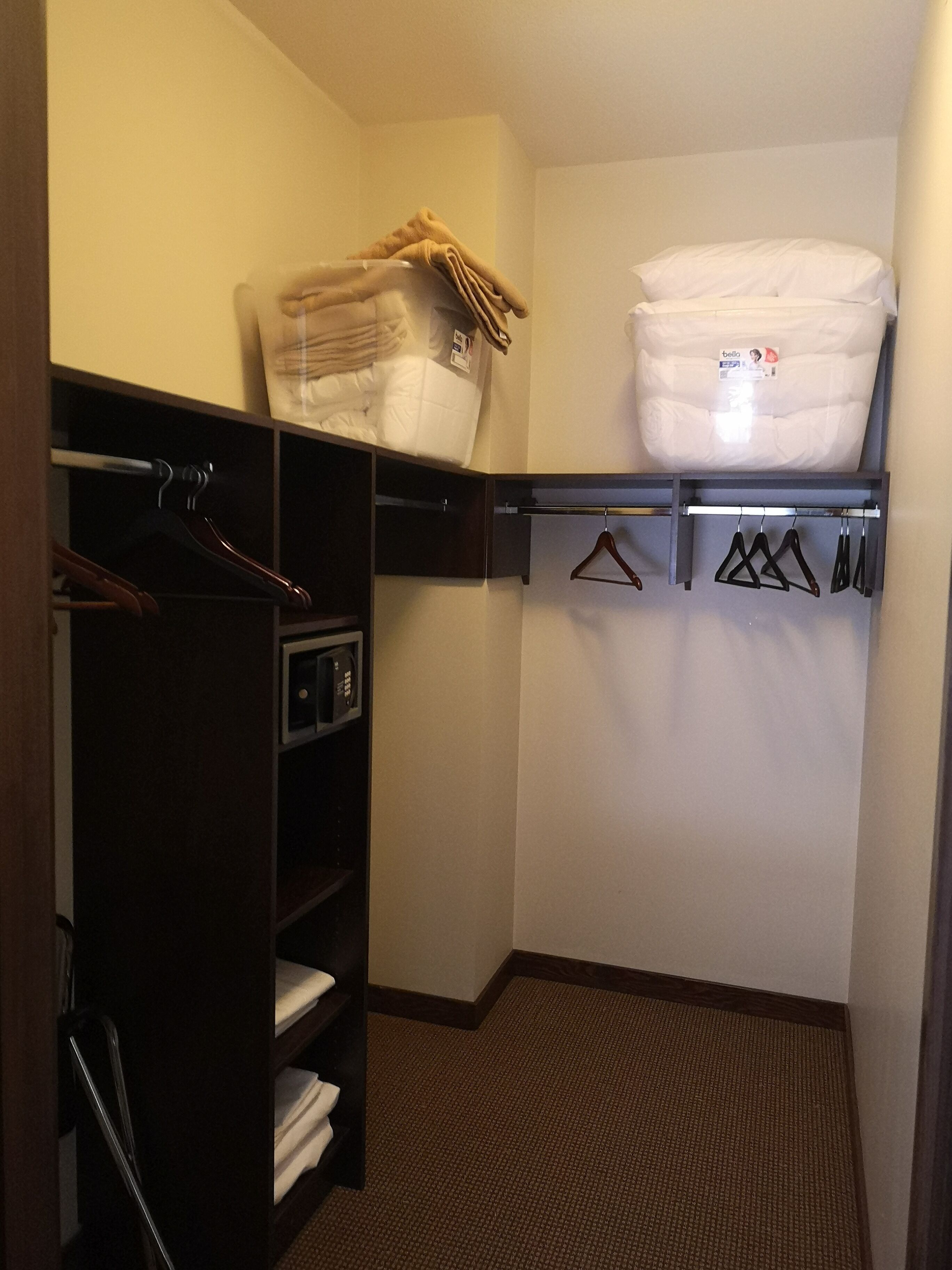 A compact closet with hanging space, shelves, and a folded bed.
