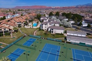 Zona residencial con varias casas, una cancha de tenis y una piscina.