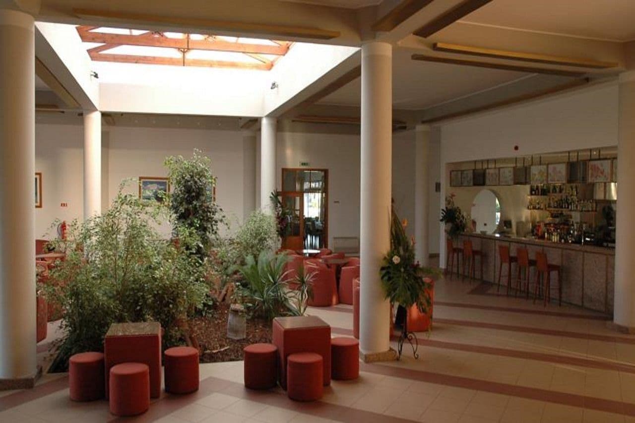 A spacious lobby with a high ceiling, a bar area, and seating arrangements.