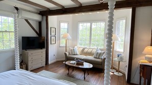 Una camera da letto con un letto a baldacchino, una televisione, un divano e un tavolino.