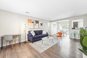 Relax in this stylish living room with a blue sofa, round coffee table, and comfortable armchair.