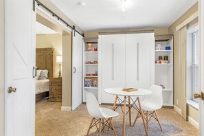 Cozy retreat with a round table, comfortable chairs, and a neatly made bed.