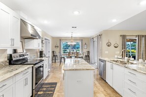 Enjoy cooking in this well-lit kitchen with a central island and large window offering a view of the outdoors.