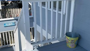 A white deck with a sign reading "OCEAN" and a bucket labeled "FLY FLIP GLOPS" on the deck. - Beach house with pool only steps from the ocean (Murrells Inlet)