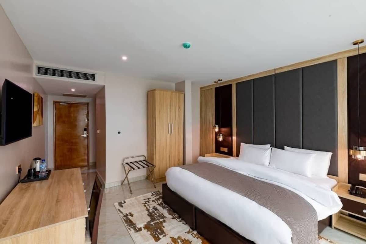 Ett modernt hotellrum med en stor säng, ett skrivbord och en TV.