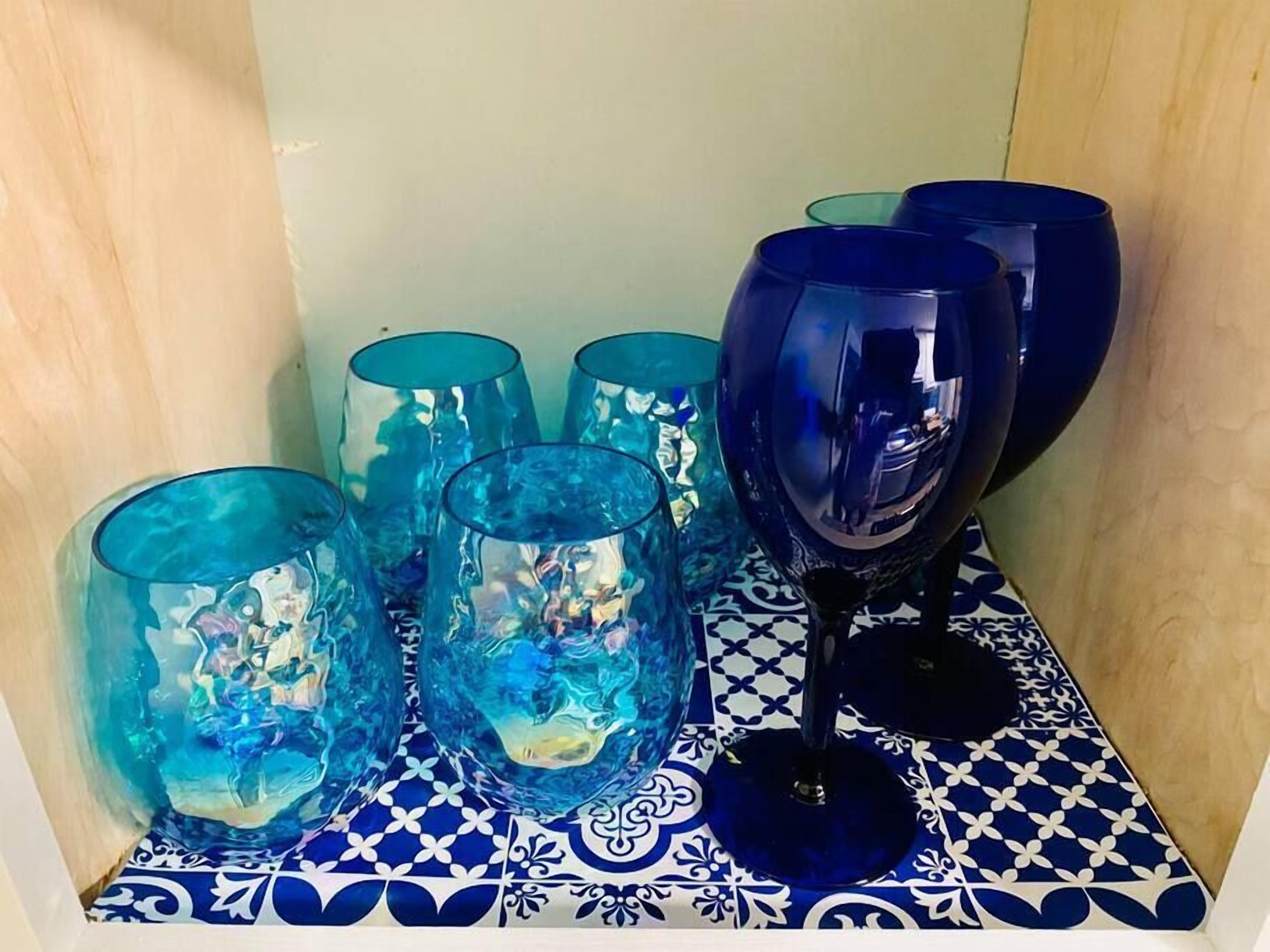 Un ensemble de verres bleus disposés sur un plateau à motifs.