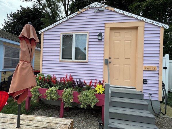 A small, single-story house with a beige door and a window.