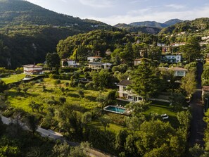 Un quartier résidentiel où les maisons sont entourées d’une végétation luxuriante et de collines.