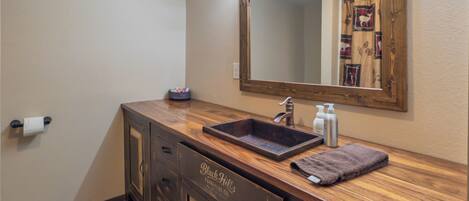Une salle de bain avec un meuble-lavabo en bois, un grand miroir et un évier.