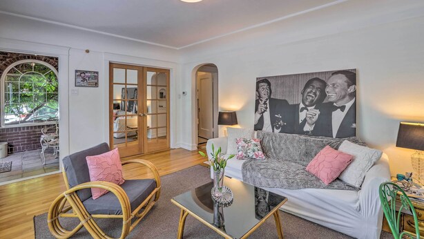 A living room with a sofa, chairs, a coffee table, and a large painting on the wall.