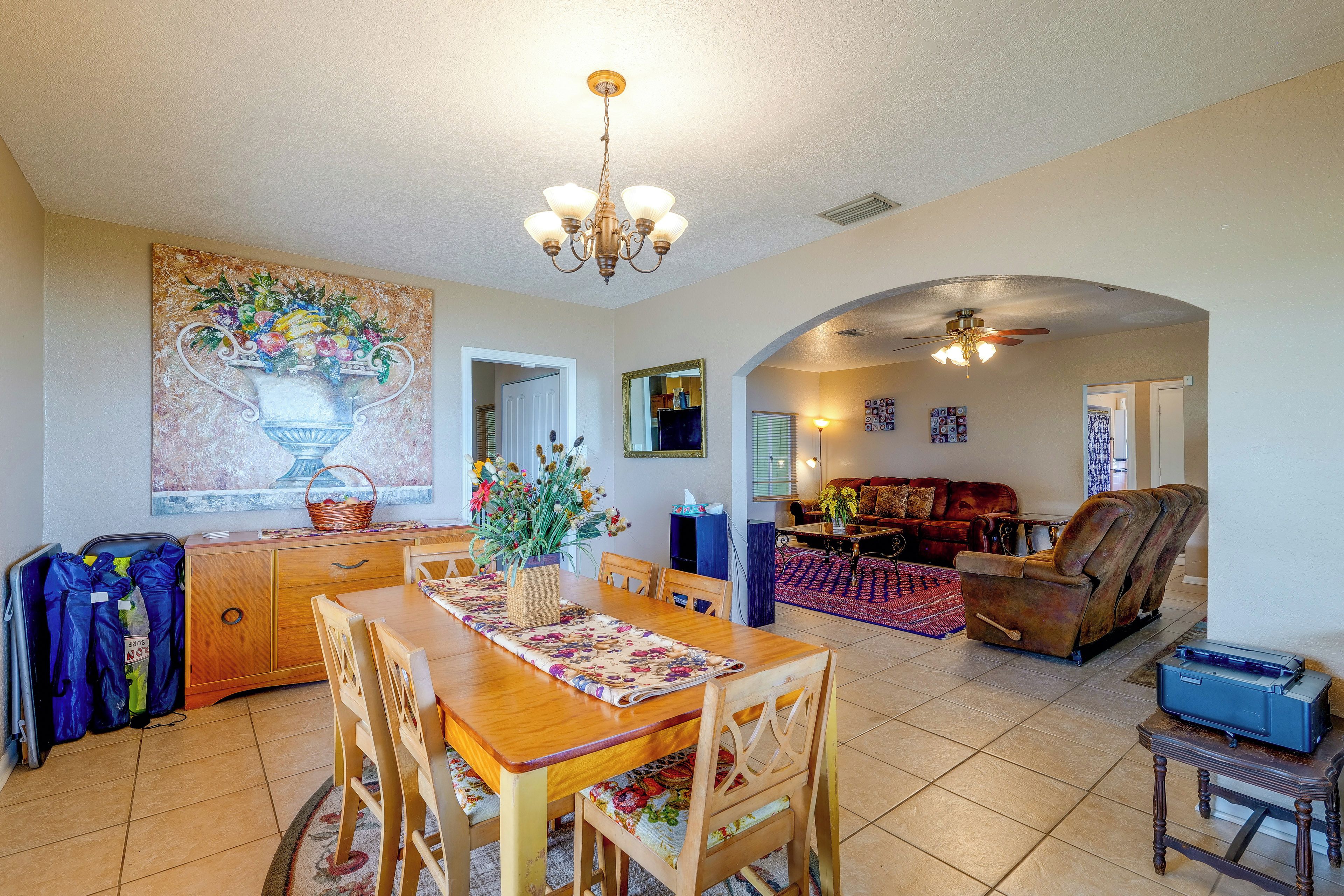 A spacious living area with a dining table, chairs, a sofa, and a fireplace.