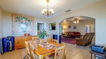 A spacious living area with a dining table, chairs, a sofa, and a fireplace.