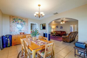 A spacious living area with a dining table, chairs, a sofa, and a fireplace.