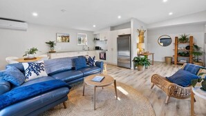 A modern living room with a sofa, coffee table, and wicker chair.