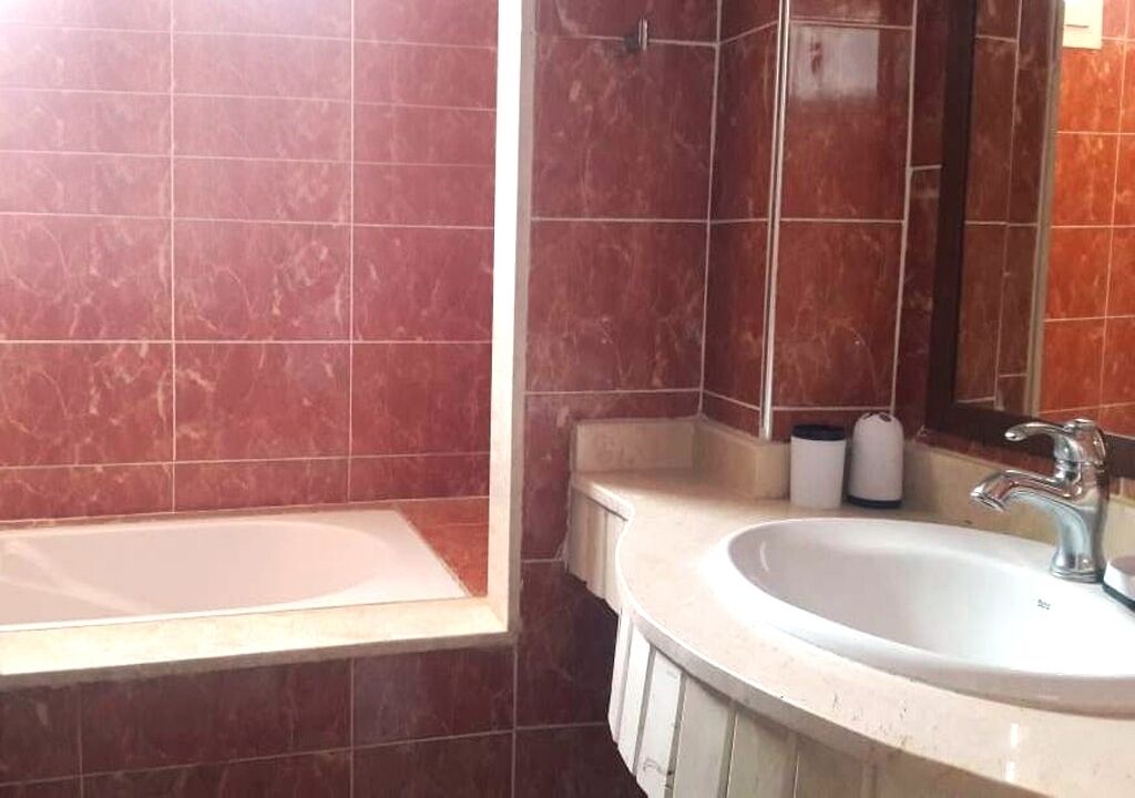Une salle de bain avec une baignoire, un lavabo et un miroir.