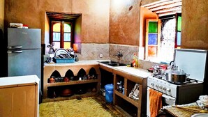 A compact kitchen with a refrigerator, sink, stove, and a window with colorful panes. - DAR BOUMIDA 5423 Lalla Takerkoust (Lalla Takerkoust)