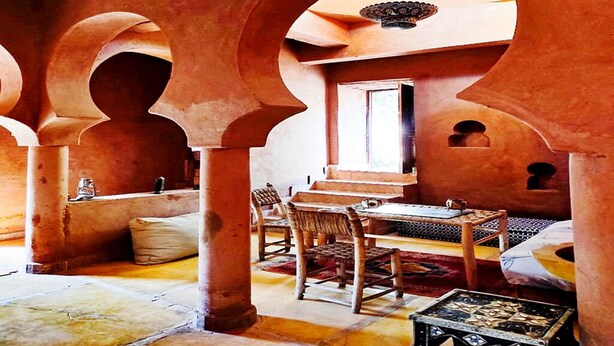 A traditional interior with arches, a dining area with a table and chairs, and a patterned rug. - DAR BOUMIDA 5423 Lalla Takerkoust (Lalla Takerkoust)