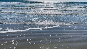 Una platja amb onades i cel blau.