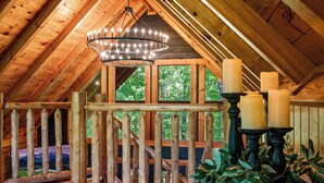 Un interior de madera con una escalera, un candelabro y velas.
