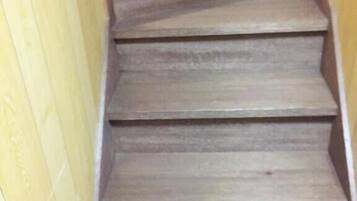 A wooden staircase with a handrail, leading to an upper floor.