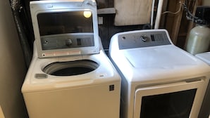Una lavatrice a carica frontale e un'asciugatrice affiancate in una lavanderia.