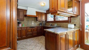 Eine Küche mit Holzausstattung, Granit Arbeitsplatten und einem eingebauten Backofen.