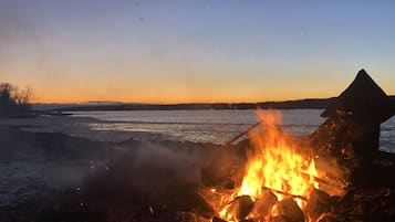 Enjoy a peaceful evening by the sea with a campfire on the beach.