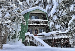 Un bâtiment à deux étages, avec un toit enneigé et un balcon.