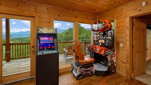A wooden cabin with a gaming console and racing game setup.