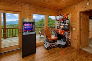 A wooden cabin with a gaming console and racing game setup.