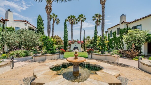A courtyard with a central fountain, surrounded by palm trees and various plants. - Condo in Trendy Neighborhood Within Walking Distance to Beach! (Santa Barbara)