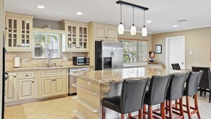 A spacious kitchen with a large island, built-in appliances, and a dining area with bar stools.