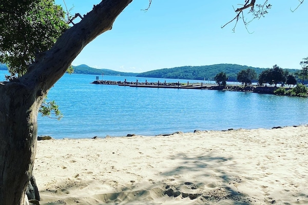 Una playa cerca, sillas reclinables de playa, toallas de playa