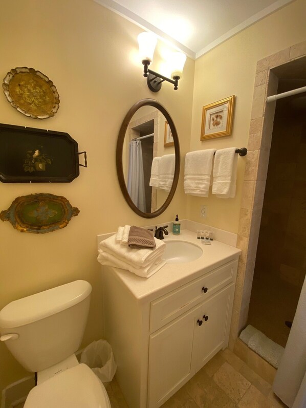 A bathroom with a toilet, sink, mirror, and shower. - Spacious 4 BR 4 BA Home--Close to Beach, Village, Pier, WINTER DISCOUNTS (St. Simons Island)