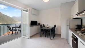 Cocina compacta con comedor, televisor y vistas a la montaña.