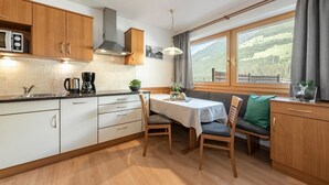 Una cocina con armarios de madera, una estufa y un comedor con mesa y sillas.