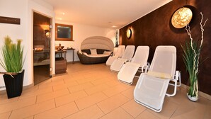 Un cuarto de spa con una silla de masaje, un espacio de relajación y un mostrador de recepción.