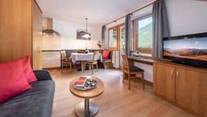 Een compacte leefruimte met kitchenette, eethoek en televisie.